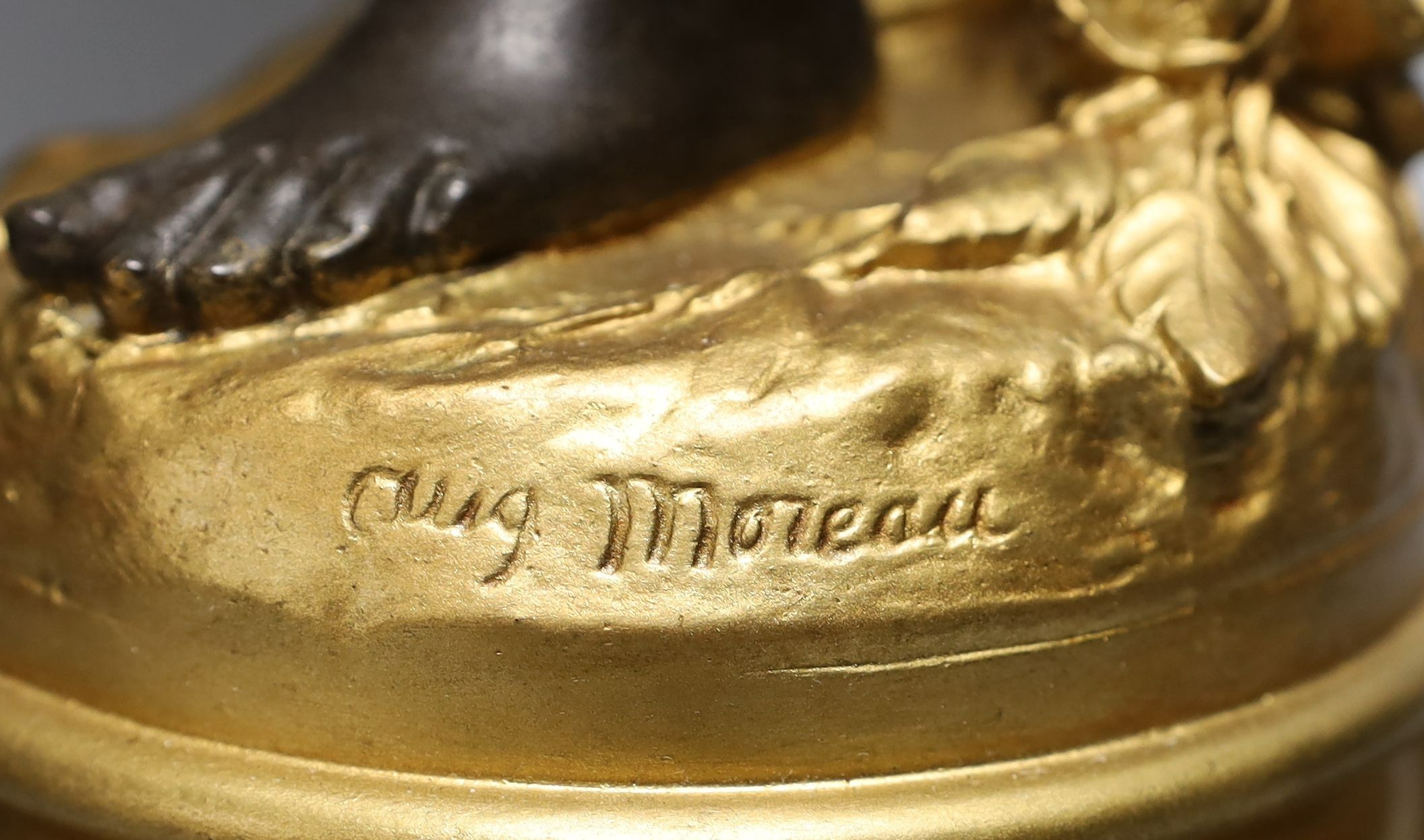 A gilt and brown patinated spelter putto lamp with flame glass shade, signed Moreau